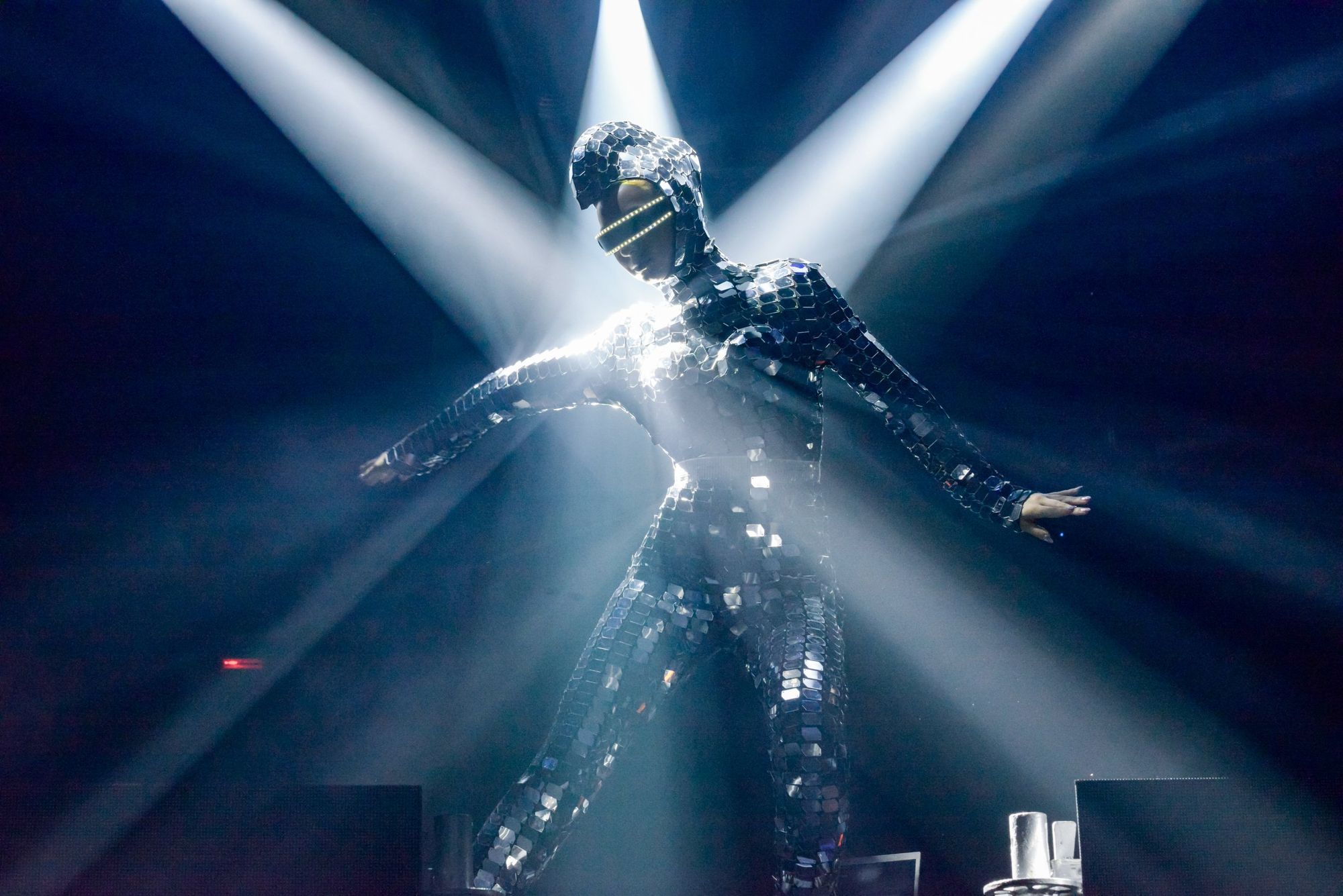Performer con traje espejado bajo haces de luz en un evento producido por SOMOS 360